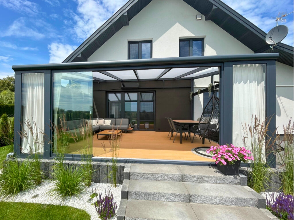 Zabudowa tarasu Garbów z konstrukcją aluminiową RAL 7016 i bezramową zabudową szklaną