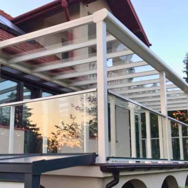 Zadaszenie tarasu Janów Lubelski – konstrukcja RAL 9001 z przeziernym szkłem i balustradą szklaną